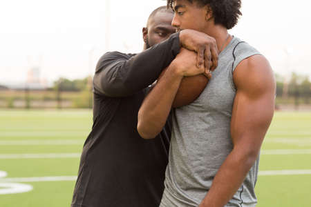 American Football coach training a young athlete.の写真素材
