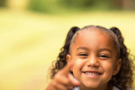 Cute mixed race little girl laughing and smiling.の写真素材