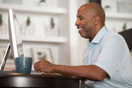 Mature African American man working from his home office.の写真素材