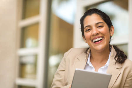 Hispanic business woman smiling outside stock photo
