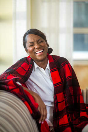 Mature woman sitting on her sofa at home.の写真素材