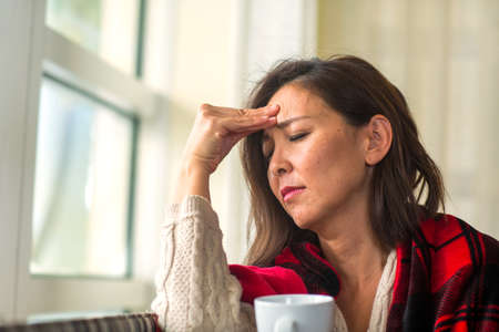 Portrait of a mature Asian woman in deep thought.