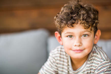 Handsome young boy with curly hair smiling.の写真素材