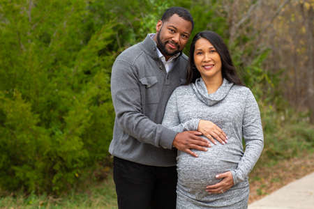 Portrait of a mixed race couple who are expecting parentsの写真素材