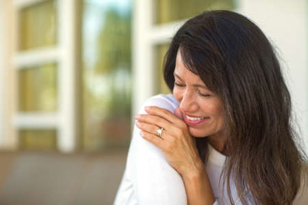 Portrait of a beautiful mature woman sitting on the sofaの写真素材