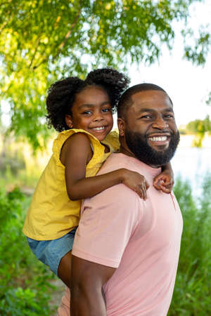 Father and daughter smiling and laughing outside.の写真素材