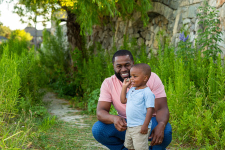 African American man playing with his son at the park.の写真素材