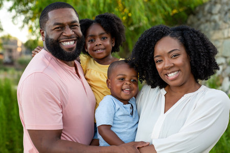 Happy African American family outside at a park.の写真素材