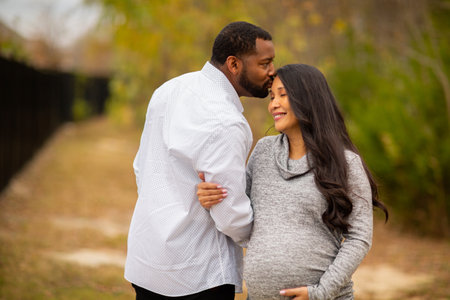 Portrait of a mixed race couple who are expecting parentsの写真素材