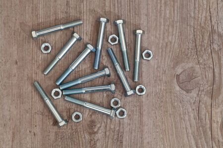 screws and bolts for carpentry on wooden background