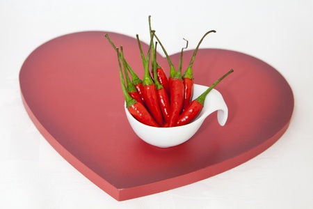 bunch of spicy, hot red peppers on a heartの写真素材