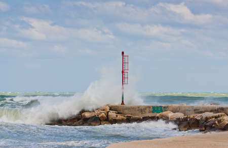 Stormy sea and big waves on a small harbor in the south of italyの写真素材