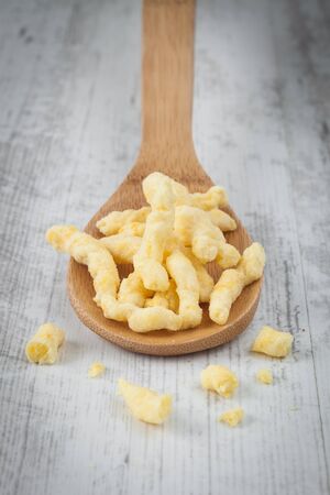 Fried potato chips on a wooden spoonの写真素材