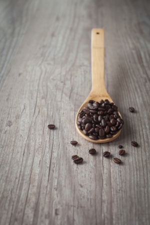 Bunch of coffee beans on a wooden spoonの写真素材