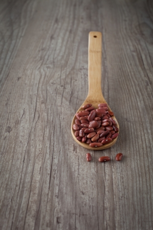 Bunch of fresh raw beans on a wooden spoonの写真素材