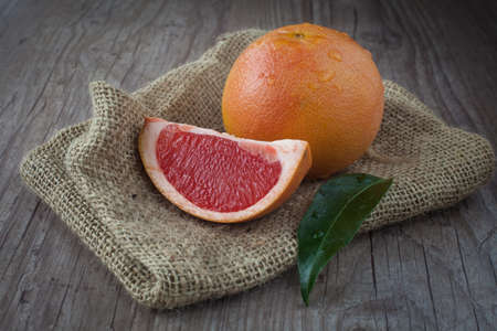 Fresh pink grapefruit on a wooden backgroundの写真素材