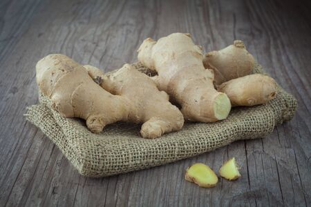 Bunch of fresh ginger roots on a wooden background