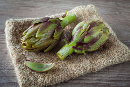 Assortment of fresh artichokes on wooden backgroundの写真素材