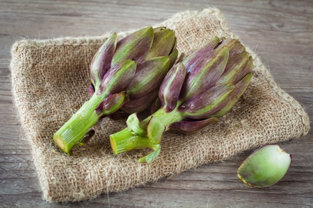Assortment of fresh artichokes on wooden backgroundの写真素材