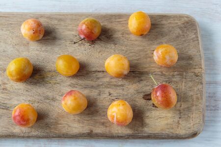 Fresh sweet mirabelle plums on a chopping boardの写真素材