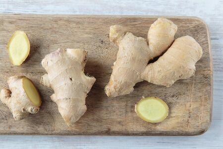 Fresh healthy ginger root on chopping boardの写真素材