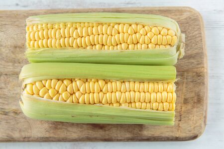 Fresh raw corncob on a chopping board