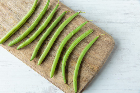 Fresh raw green beans on a chopping board