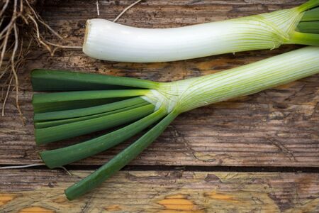 Fresh raw spring onions on a wooden boardの写真素材