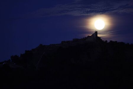 A full moon is  above a Szigliget  castleの写真素材