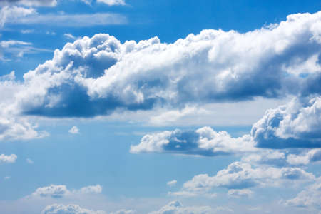 White cumulus clouds and a blue sky.