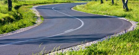 Beautiful curved asphalt road on sunny dayの写真素材
