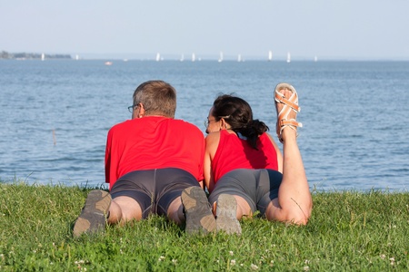 Joyful young couple is overlaping shore of the lakeの写真素材