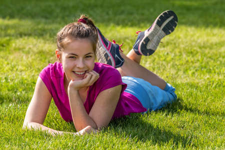 Happy young girl poses in front of the camera の写真素材