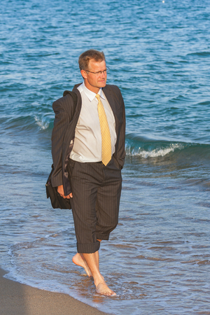 Young businessman walking on th e beach after the work timeの写真素材