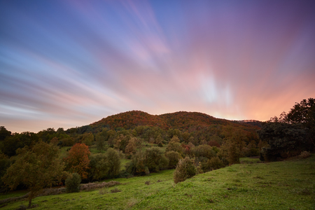 Nice long exposure picture, cloudscape over the mountain in sunset and autumn colorsの写真素材