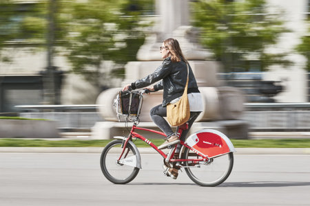 Young woman go to work with special renting bike, Bicing, in Barcelona of Spain. Long exposure technique picture. 15. 04. 2015 Spainのeditorial素材