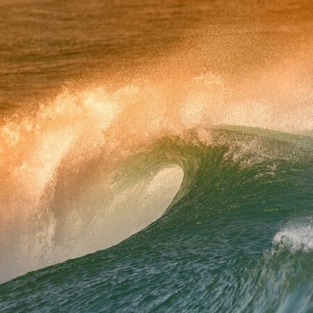 Beautiful big ocean wave with sunset color