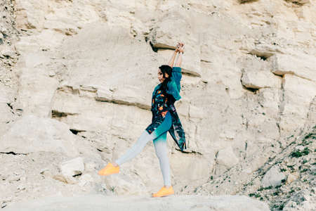 Young woman dressed colorful clothes posing and dancingの写真素材
