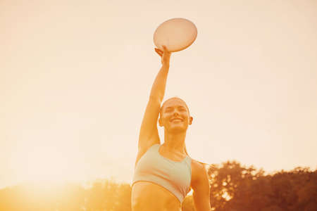 Young athletic girl playing with flying disc in the park. Professional player. Sport conceptの写真素材