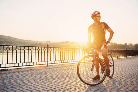 Young and energetic cyclist in the park. Man are cycling road bike by the lake in the parkの写真素材