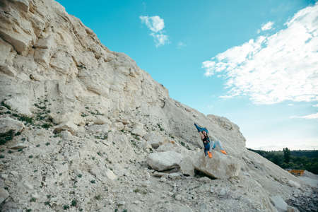 Young woman posing and dancing near the beautiful mountains dressed colorful clothesの写真素材