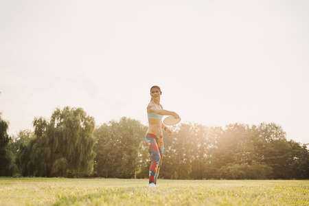 Young athletic girl playing with flying disc in the park. Professional player. Sport conceptの写真素材