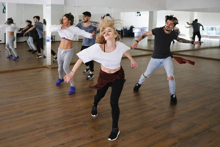 Group of young modern dancers dancing in the studio. Sport, dancing and urban culture concept