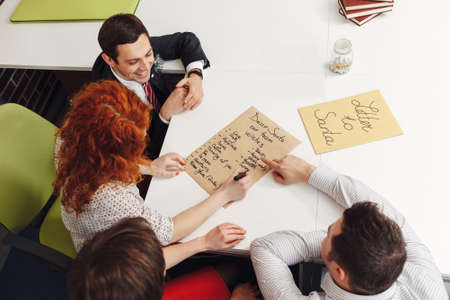 Co-workers having fun at Christmas day, writing a letter to Santa Claus. Top view.