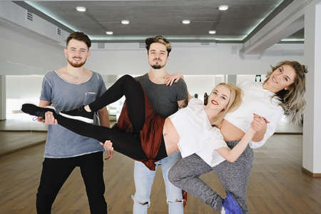 A group of dancers holding their dancing partner up smiling. Hip-hop dancers posing for a party posterの写真素材