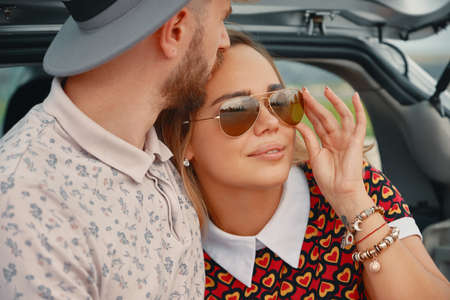 Close up young, attractive man kissing with affection forehead of his beautiful girlfriend and...