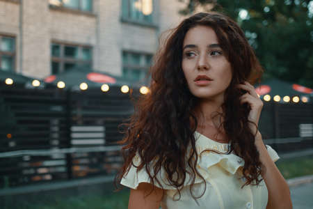Close-up portrait of beautiful caucasian woman with lights in background, posing outdoors.の写真素材