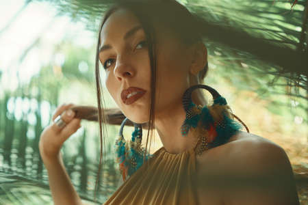 Stunning fit woman among tropical plants. Beauty, fashion. Spa, healthcare. Tropical vacation. Dancingの写真素材