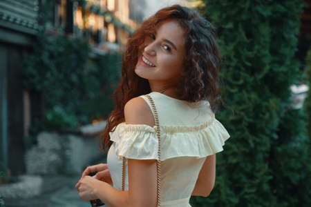 Close-up portrait of beautiful caucasian woman with charming smile walking, posing outdoors.の写真素材