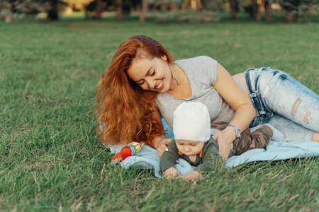 Happy and smiling mother with her baby spending time in the parkの写真素材